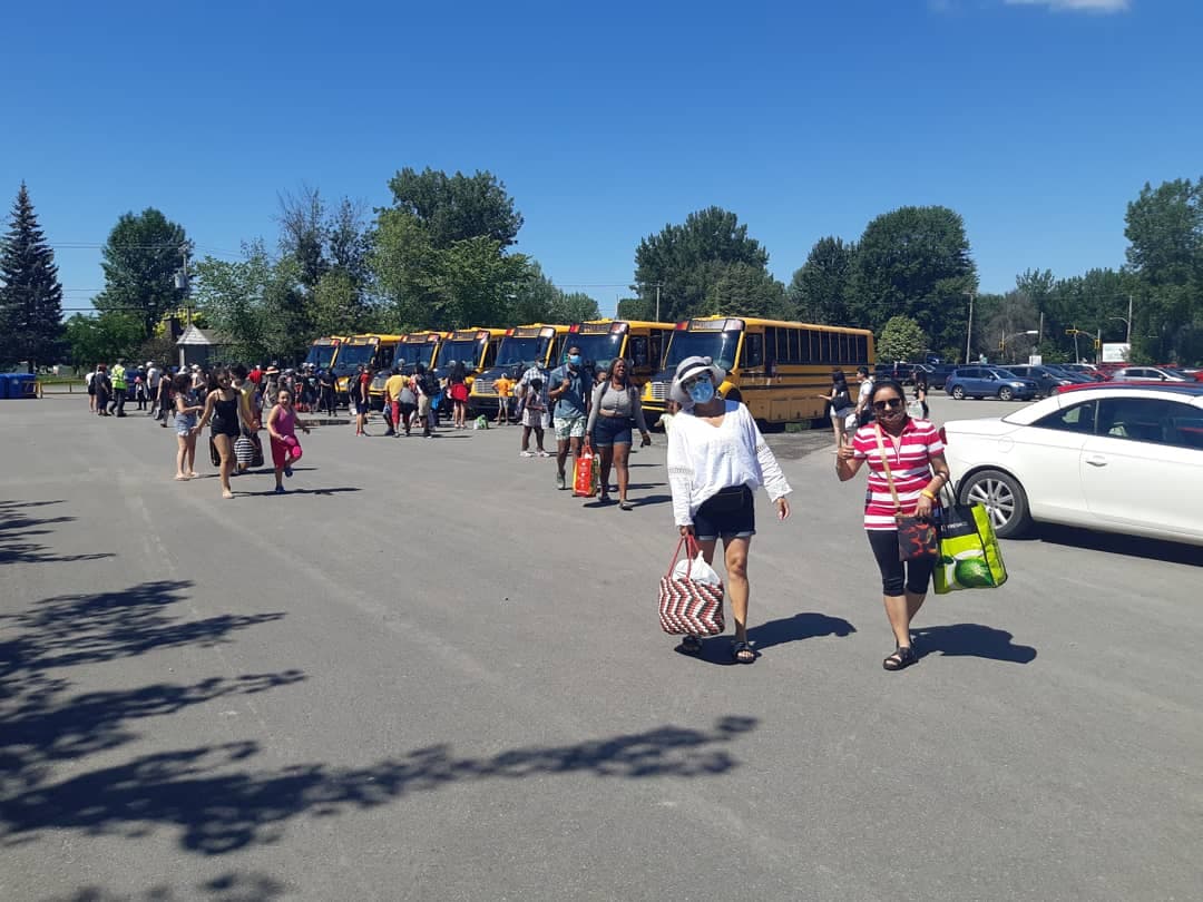 Les gens descendent de sept autobus scolaires